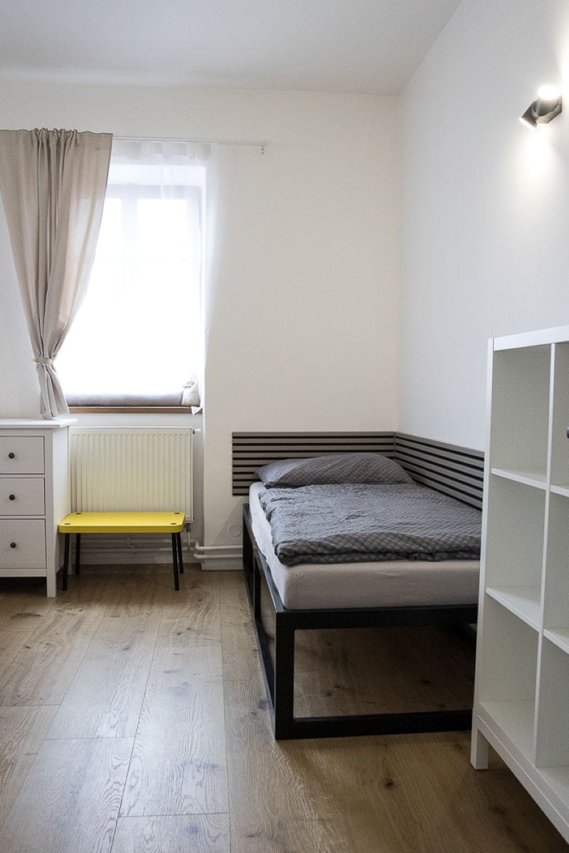 Une chambre à coucher avec un lit, un bureau, une chaise et un radiateur.