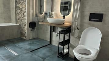A modern bathroom with a bathtub, a sink, a toilet, and a shower.