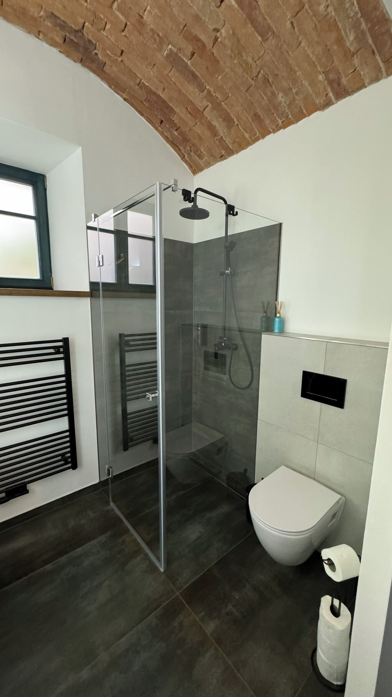 Un baño moderno con ducha de vidrio, inodoro y barra para toallas.