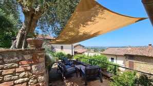 An outdoor patio with stone walls, a table and chairs, and a view of the surrounding landscape. - Apartment 'La Terrazza, Cetona, Toscana' with Mountain View, Wi-Fi and Air Conditioning (Cetona)