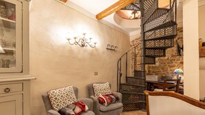 A cozy living room with two armchairs, a staircase, and a wall-mounted light fixture. - Apartment 'La Terrazza, Cetona, Toscana' with Mountain View, Wi-Fi and Air Conditioning (Cetona)