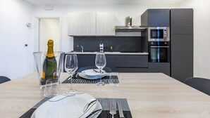 Une cuisine moderne équipée d’une table à manger pour deux personnes, d’un four à micro-ondes et d’un four encastré.