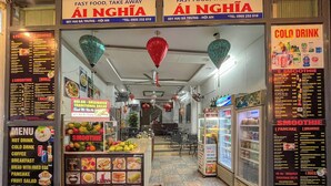 Restaurante de comida rápida com painel de cardápio, quiosque de vitaminas e refrigerador com bebidas.