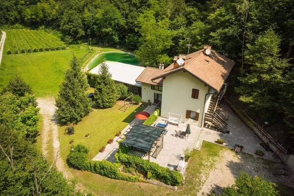 Une maison avec un jardin, un court de tennis et une piscine.