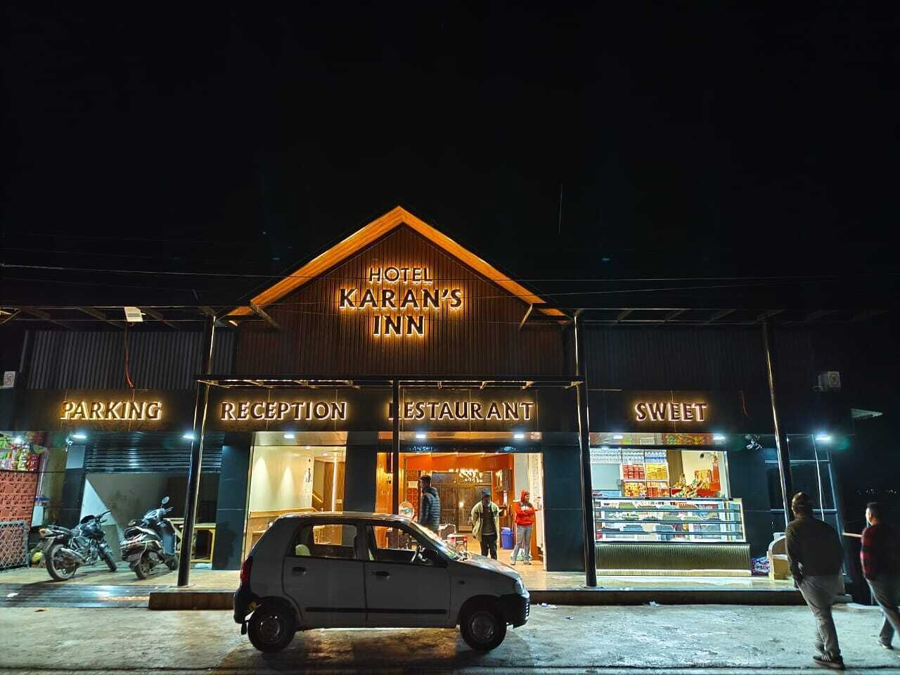 Un hotel llamado "Hotel Karan's Inn" con zonas bien delimitadas para estacionamiento, recepción, restaurante y una pastelería.
