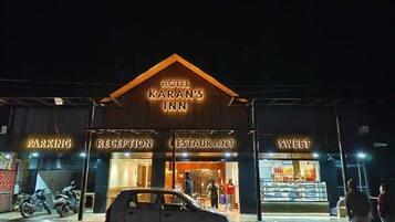 Un hotel llamado "Hotel Karan's Inn" con zonas bien delimitadas para estacionamiento, recepción, restaurante y una pastelería.