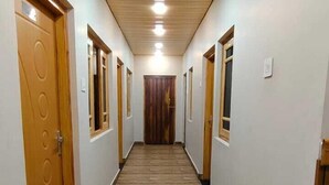 Un lungo e stretto corridoio con pavimento in legno e porte su entrambi i lati.