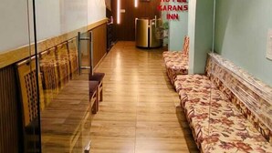 Una hall d'albergo con una reception, una zona salotto e un lampadario.