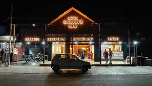 Hotel Karan's Inn con reception, ristorante e area parcheggio.