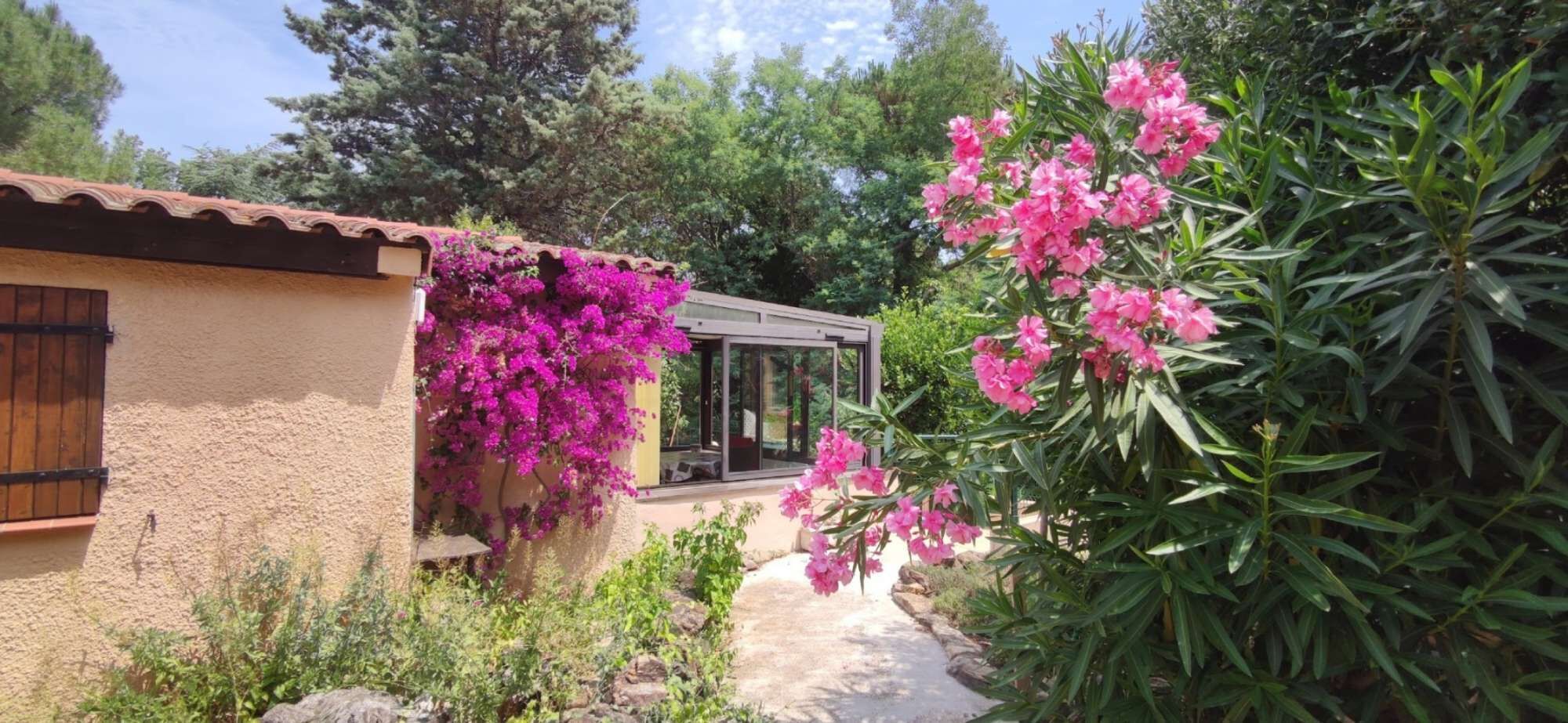 Une maison avec un jardin, une porte en bois et une fenêtre.