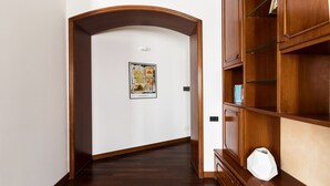 Un corridoio con una libreria in legno e un quadro appeso al muro.