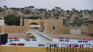 Une scène sur laquelle est accrochée une banderole portant l’inscription « Malawi Heritage Camp Sam », et une rangée de chaises disposées devant.