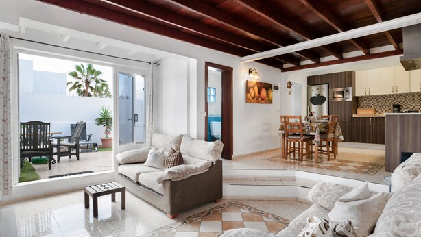 Amplia sala de estar con sofá, mesa de centro y vistas al exterior.