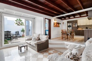 A spacious living area with a sofa, coffee table, and a view of the outside.