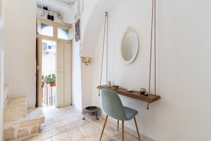 A room with a stone staircase, a wooden chair, a wooden shelf with a mirror, and a hanging swing. - Holiday Home 'Dimora Marter' with Private Terrace, Wi-Fi and Air Conditioning (Conversano)