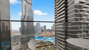 A high-rise building with a view of a cityscape, including a prominent tower and a waterfront area. - WYZ RENT|3 BDs Address Opera-Burj Khalifa (Dubai)
