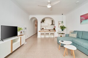 Una sala de estar moderna con televisor, sofá y mesa de centro.