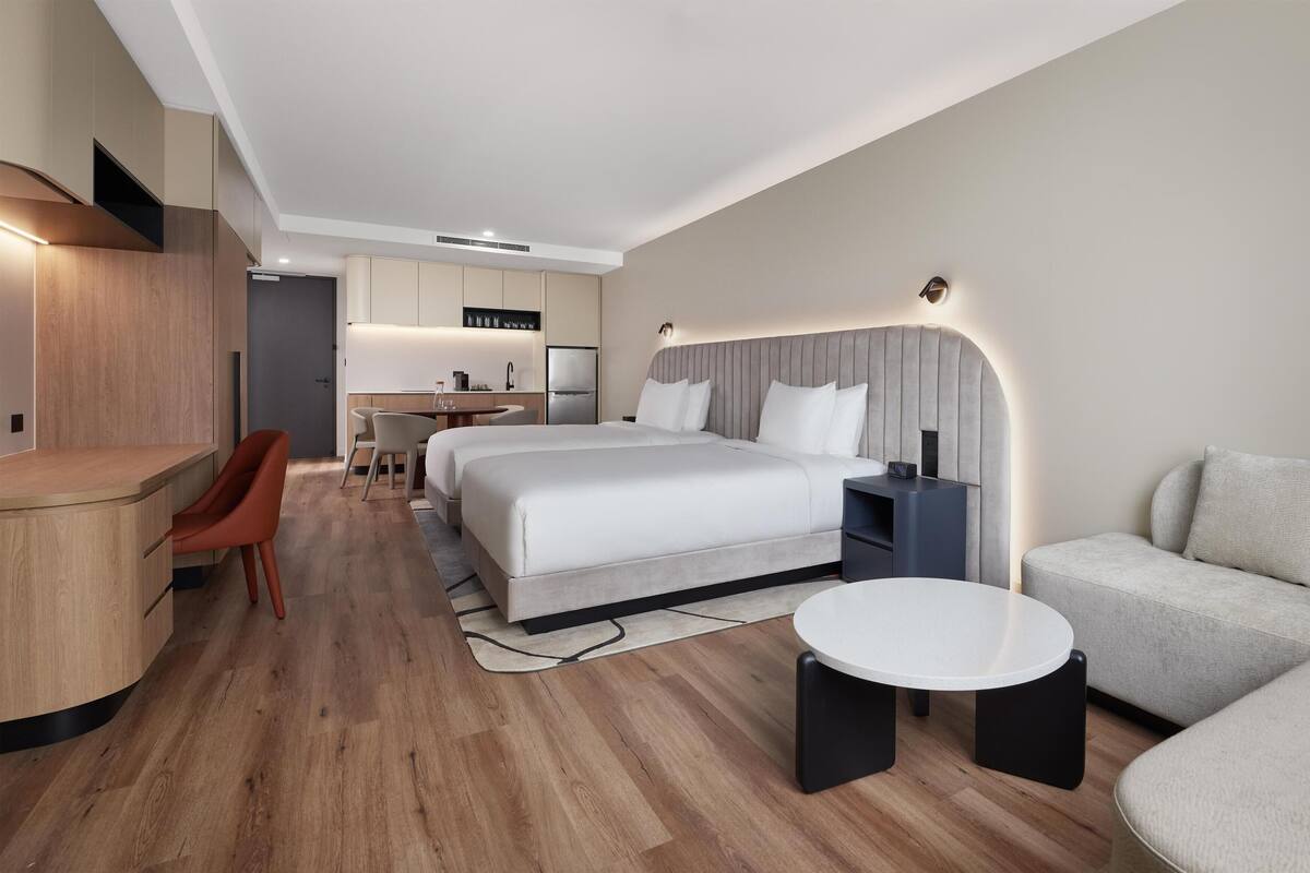 Une chambre d’hôtel moderne équipée d’un grand lit, d’un bureau, d’un canapé et d’une petite table.