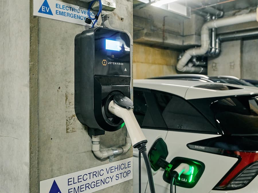 Une borne de recharge pour véhicules électriques, avec un panneau indiquant qu’il s’agit d’un arrêt d’urgence.
