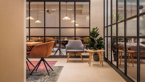 Un interior moderno con comedor, asientos y un gran ventanal con vistas.
