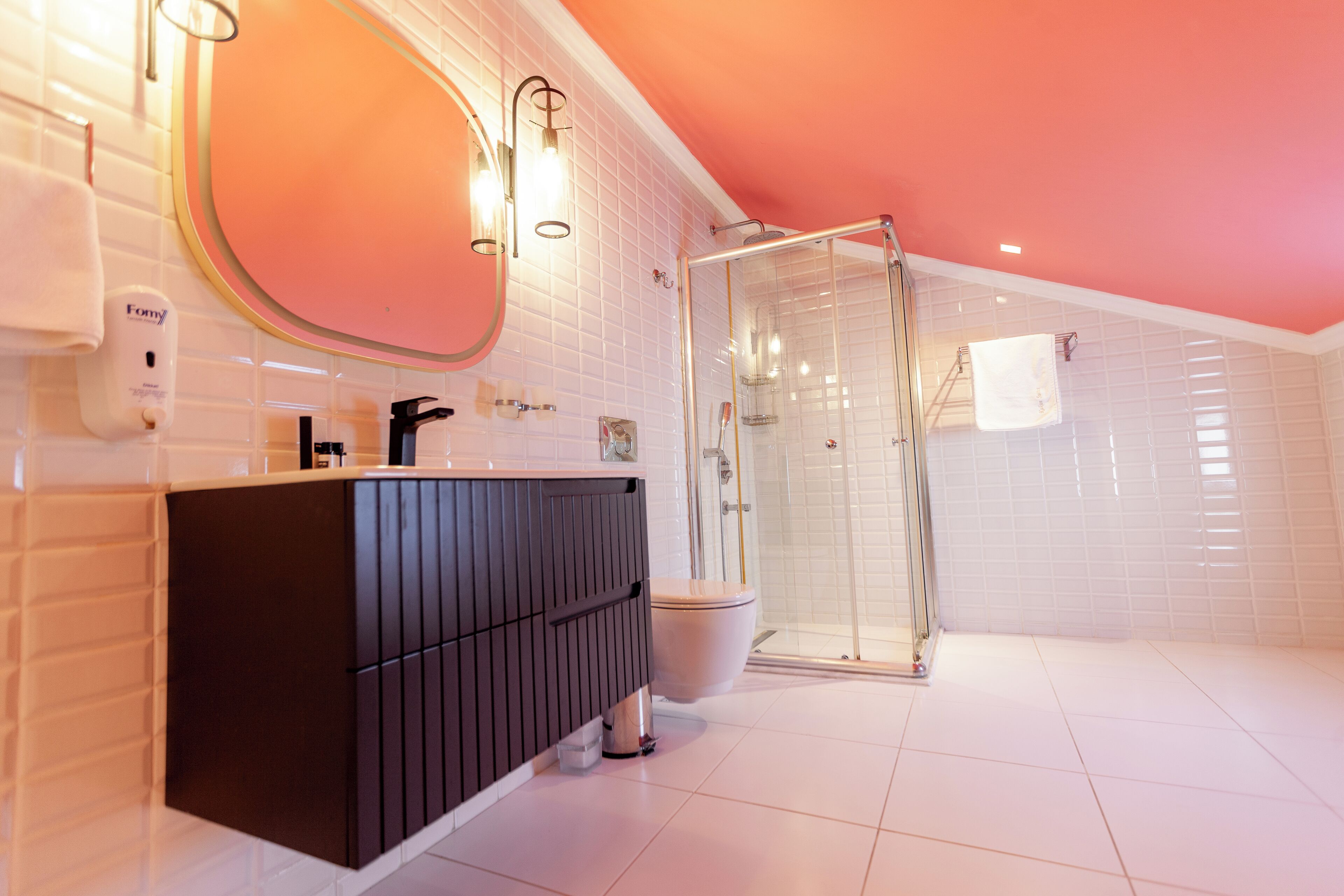 Ein modernes Badezimmer mit großem Spiegel, einer Duschkabine aus Glas und Bodenfliesen in Weiß.