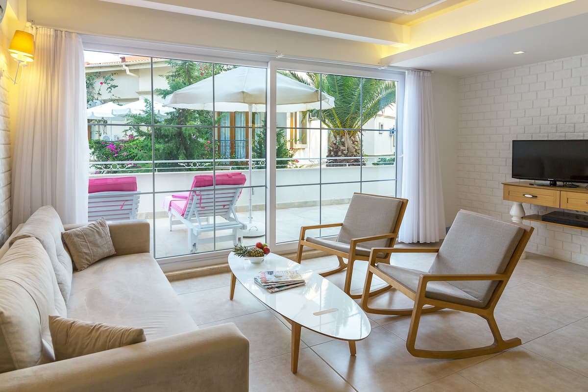 A modern living room with a sofa, chairs, a coffee table, and a TV.