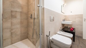 Ein modernes Badezimmer mit Dusche, Toilette, Waschbecken und Spiegel.