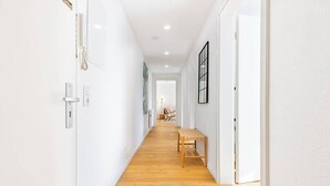 A bright hallway with white walls, wooden flooring, and a bench. - SMS Homes I time out in Blaichach (Blaichach)
