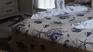 Een slaapkamer met een bed, een dressoir en een raam met jaloezieën.