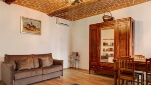 A room with a sofa, wooden cabinet, and a dining table. - Holiday Home 'Casa Dello Zio' with Mountain View, Wi-Fi and Air Conditioning (Portacomaro)