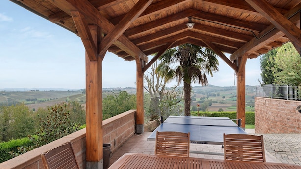 A wooden pergola with a table and chairs, overlooking a scenic landscape. - Holiday Home 'Casa Dello Zio' with Mountain View, Wi-Fi and Air Conditioning (Portacomaro)