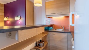 A modern kitchen with wooden cabinets, a stainless steel sink, and a built-in oven.