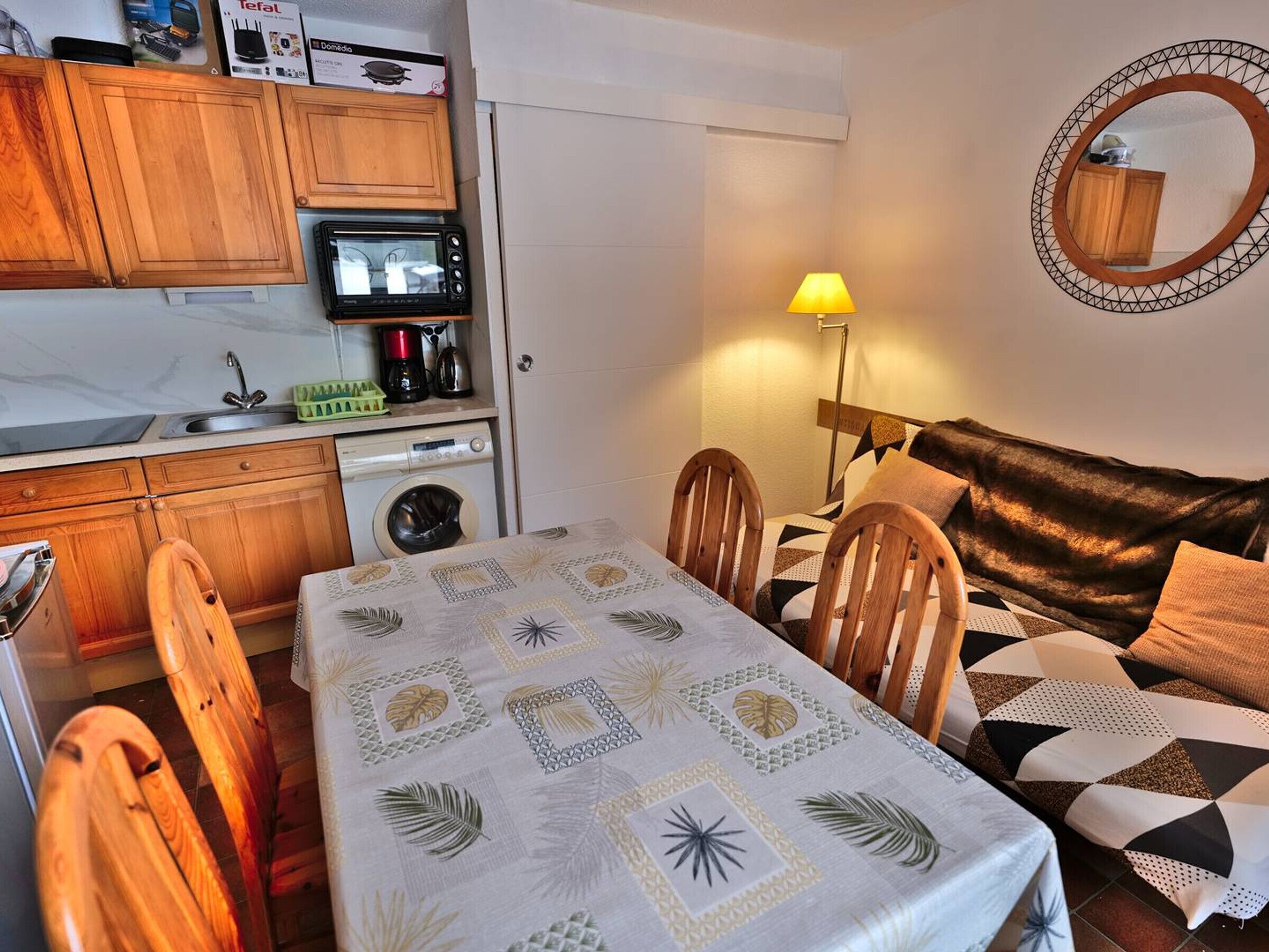A compact living space with a kitchenette, a dining area, and a sofa.