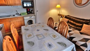 A compact living space with a kitchenette, a dining area, and a sofa.