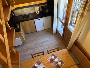 A compact kitchen with a microwave, coffee maker, and dishwasher.