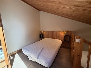 A small, single-bed room with wooden walls and a sloped ceiling. - 2-Room Duplex for 6 in Vallandry - Pets Allowed (Peisey-Vallandry)