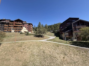 A residential area with multi-story buildings, a winding pathway, and a clear sky. - 2-Room Duplex for 6 in Vallandry - Pets Allowed (Peisey-Vallandry)