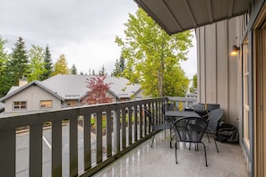 Enjoy a balcony with a view of the surrounding neighborhood, featuring a table and chairs, perfect for outdoor dining and relaxation.