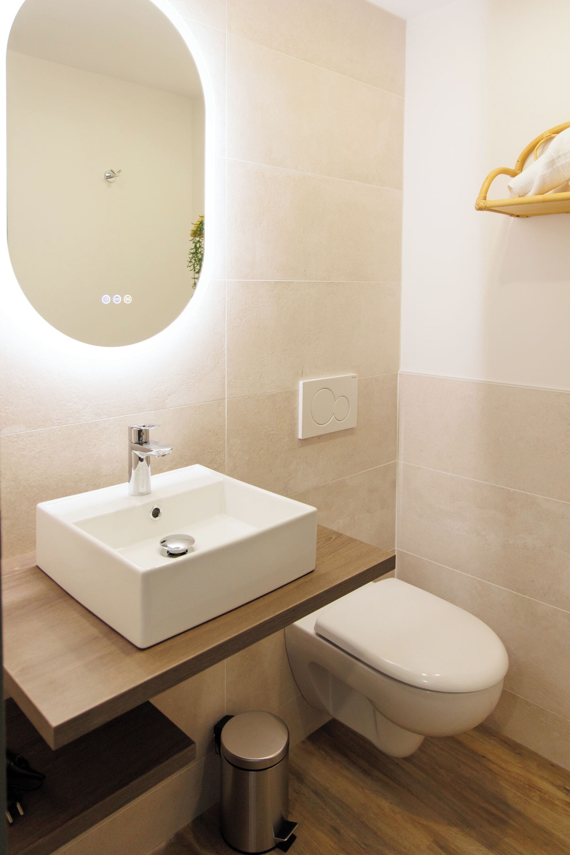 A modern bathroom with a white sink, a toilet, and a mirror.