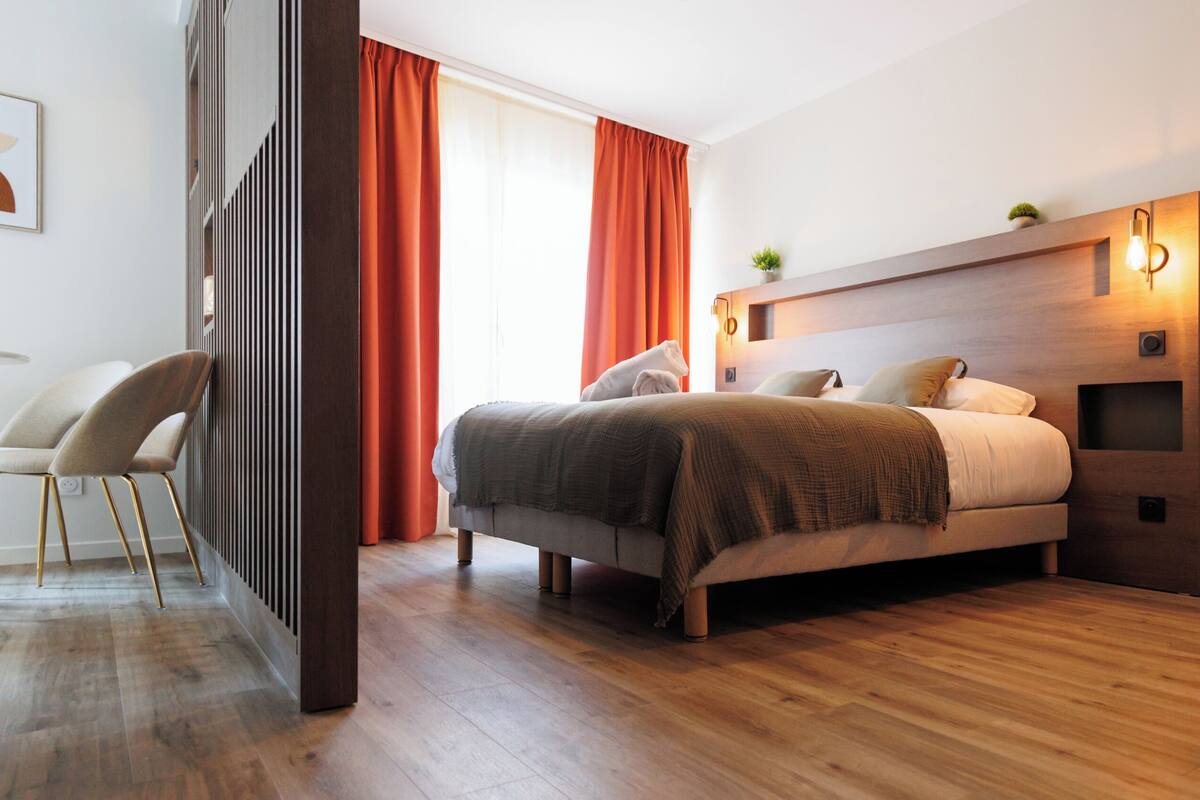 Une chambre d’hôtel moderne, dotée d’un grand lit, d’un bureau et d’une chaise.