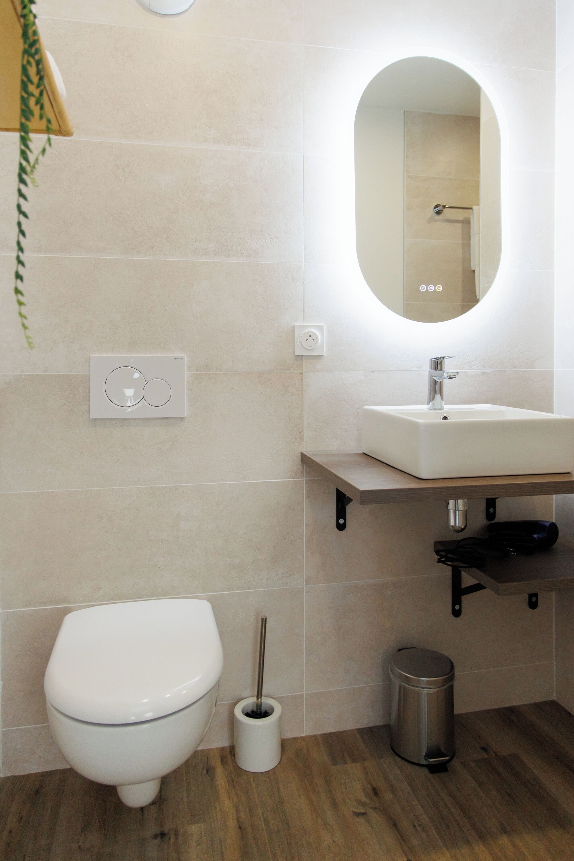 Une salle de bain moderne avec des toilettes, un lavabo et un miroir.