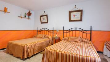 Una habitación de hotel con dos camas individuales, una mesita pequeña y estantes empotrados con objetos decorativos.