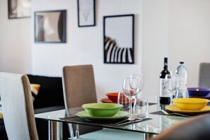 Une table à manger avec un saladier vert, un saladier jaune et des verres à vin.