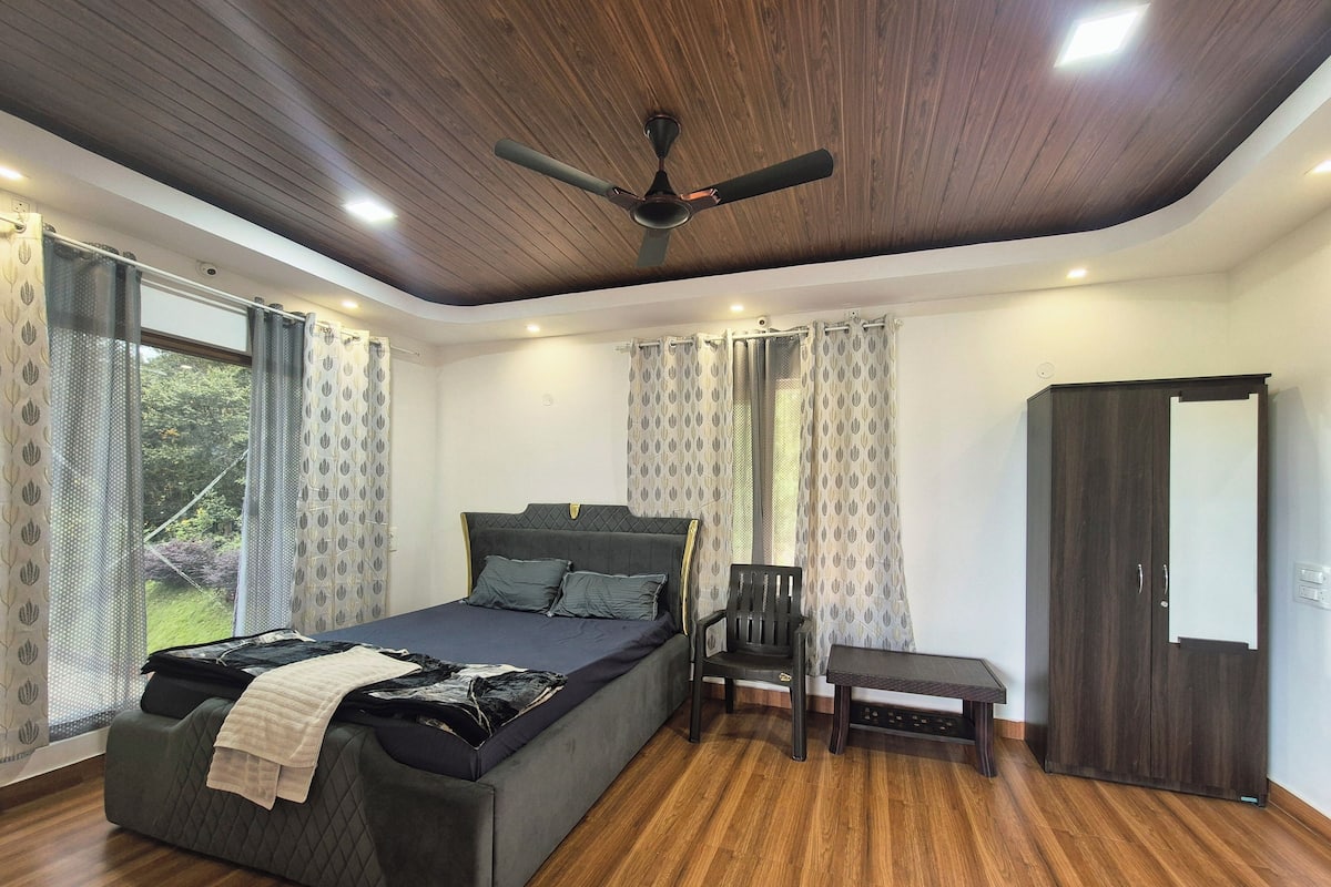 A bedroom with a bed, a chair, a wardrobe, and a ceiling fan.