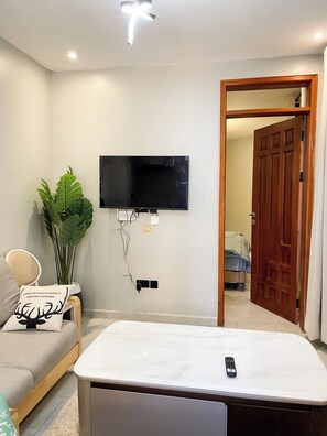 Deluxe Apartment, Balcony, City View | Living area | Flat-screen TV - Nsiimenta Stay 1BR (Kampala)