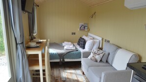 Une pièce confortable comprenant un lit, un canapé, une table à manger avec une chaise et un petit coin cuisine.
