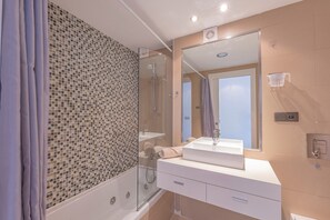 Een moderne badkamer met een douchecabine van glas, een wit wastafelmeubel en een grote spiegel.