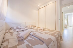 Een slaapkamer met een bed, een handdoek en een schuifdeur.