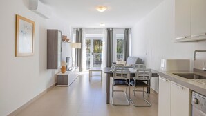 A modern kitchen with a dining area, a built-in oven, and a sink.