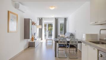 A modern kitchen with a dining area, a built-in oven, and a sink.